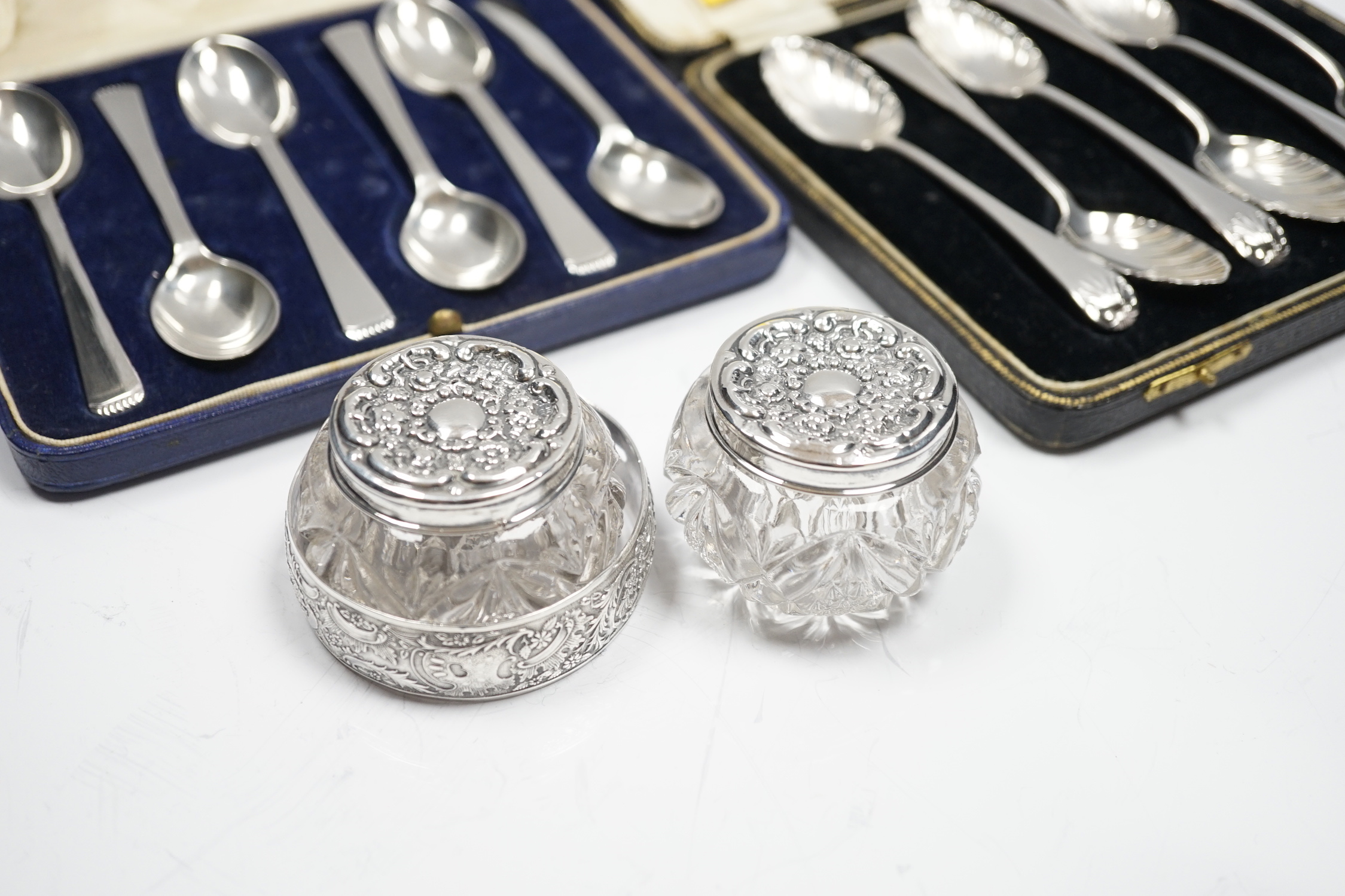 Two cased sets of six silver teaspoons, including Old English shell pattern by James Dixon & Sons, Sheffield, 1893 and Robert Pringle & Sons, Sheffield 1941, together with two silver mounted glass toilet jars and a sterl
